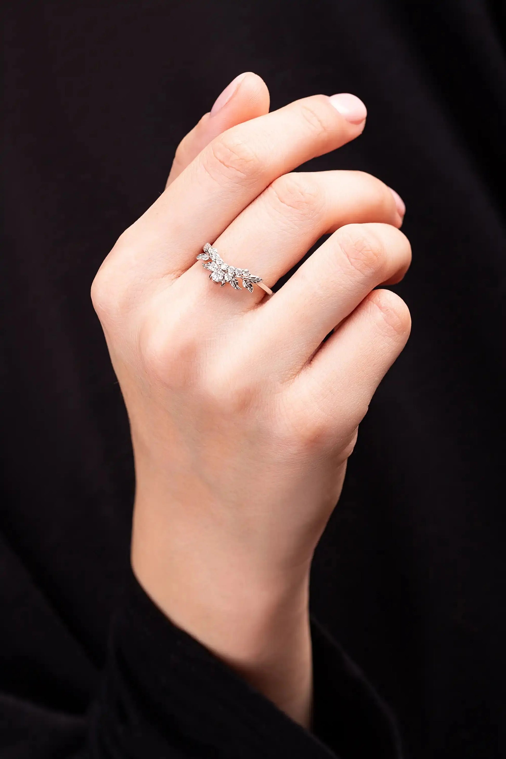 White gold ring with moissanite twig on a woman's hand