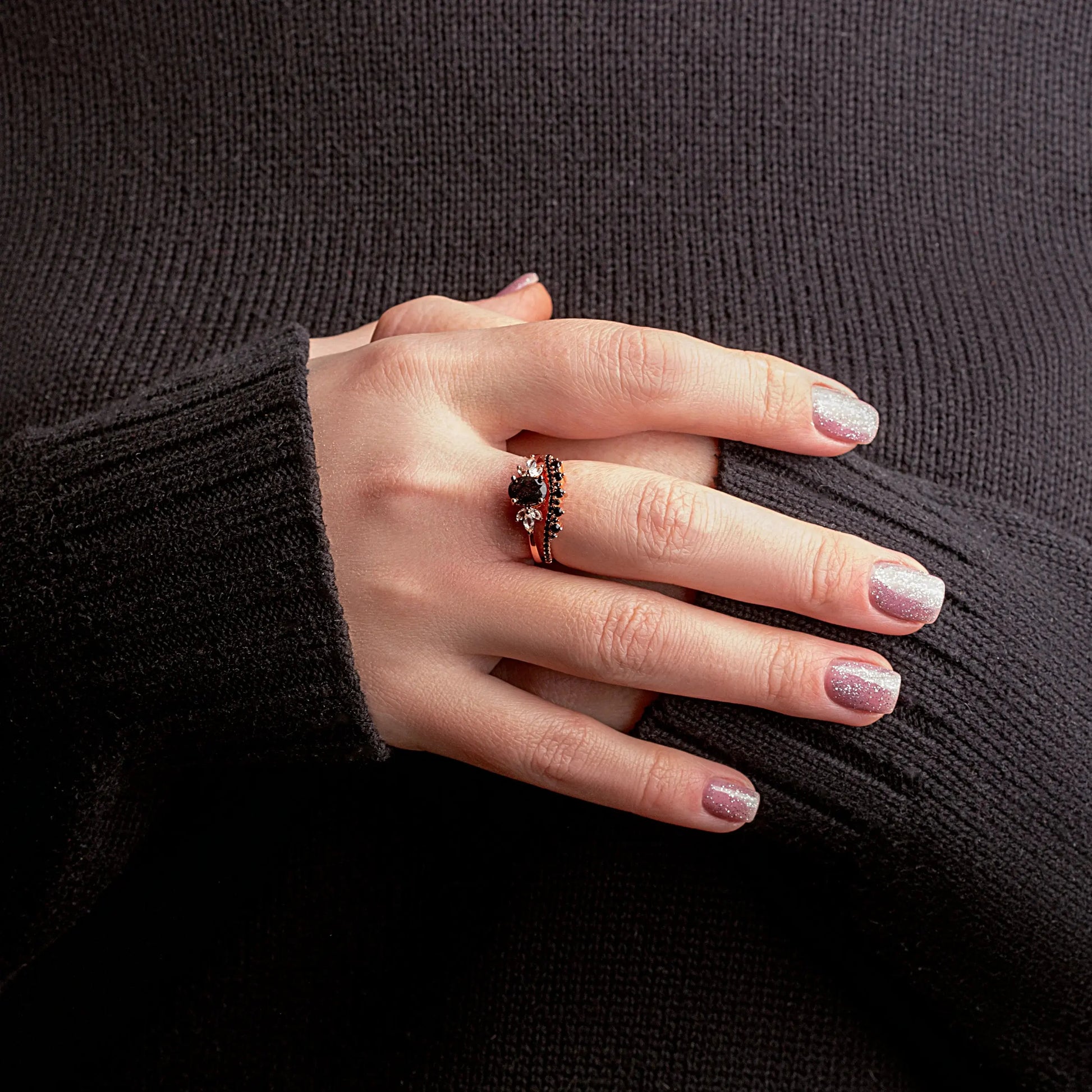 Hand wearing a ring with a dark background
