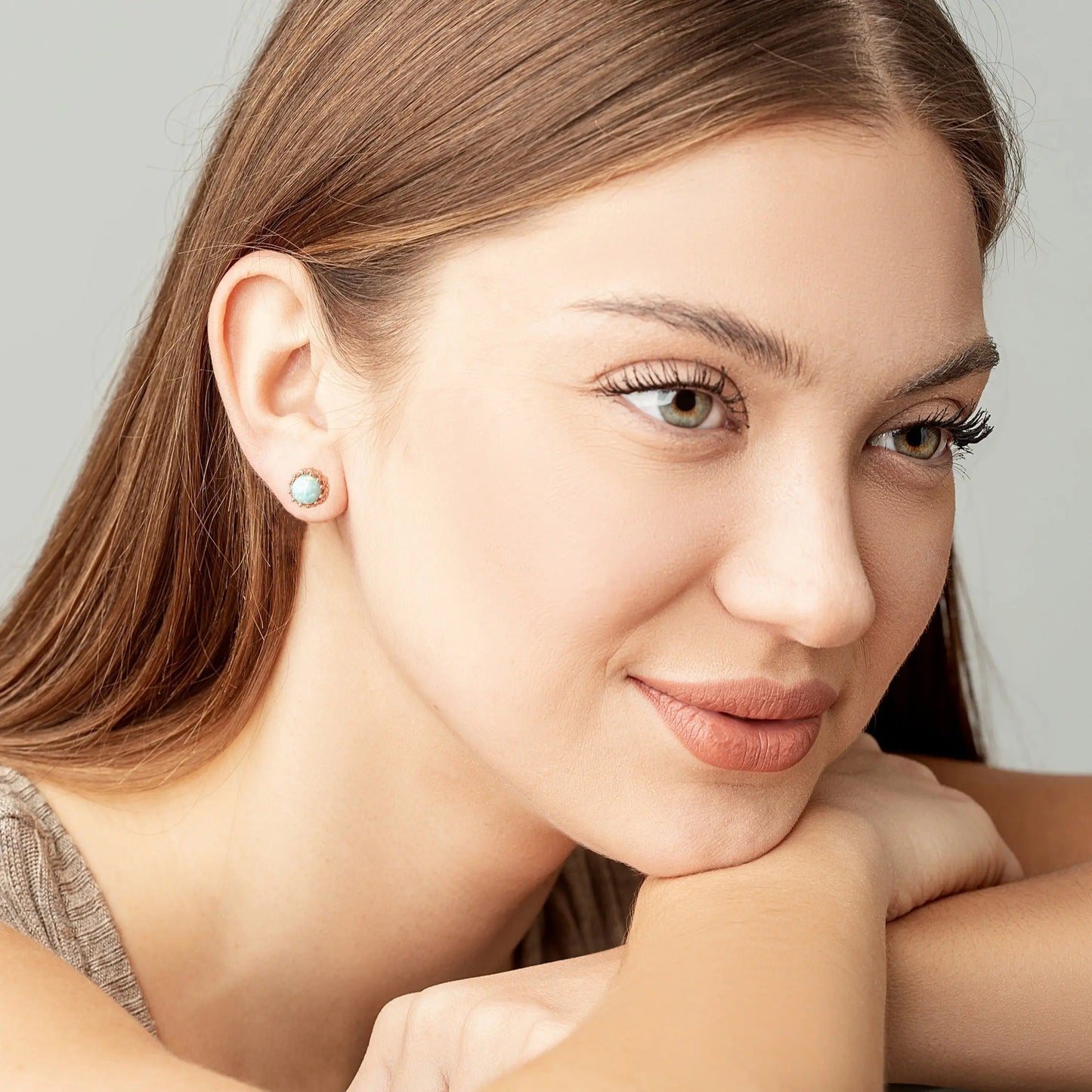 Two Green Opal crown studs on a woman ears