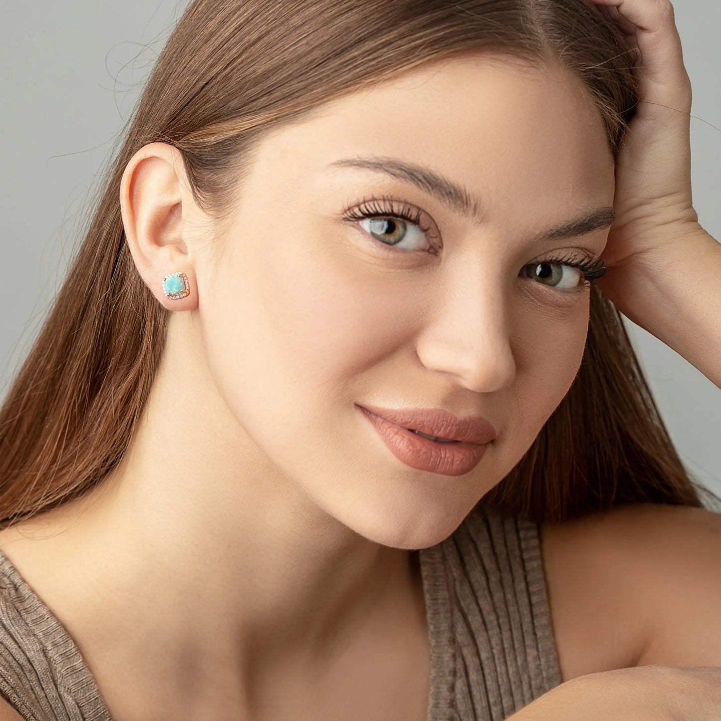 Two Green Opal square studs on a woman ears