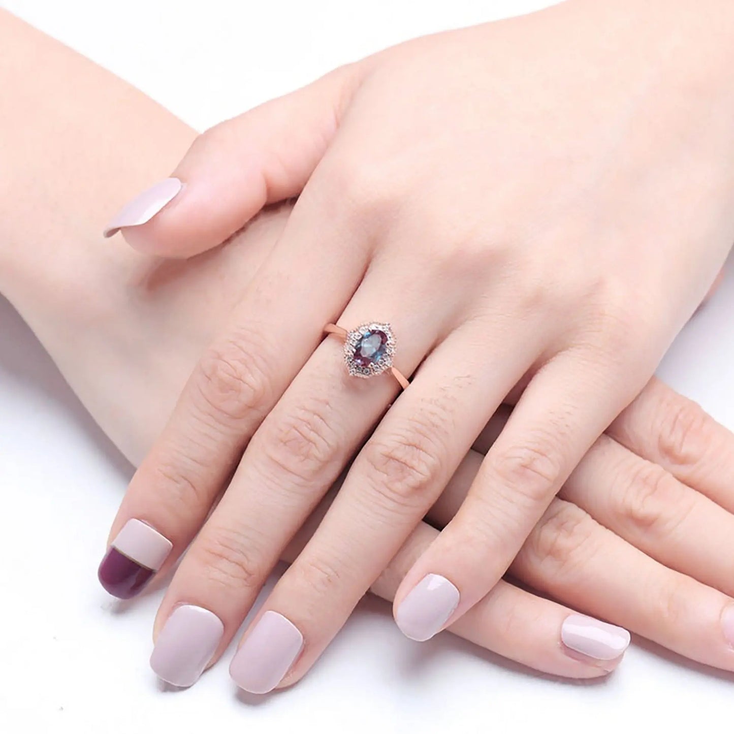 Zircon ring with a dark blue alexandrite on a woman crossed hands