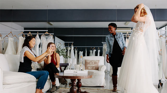 Bride and her bridesmaids are choosing wedding dress