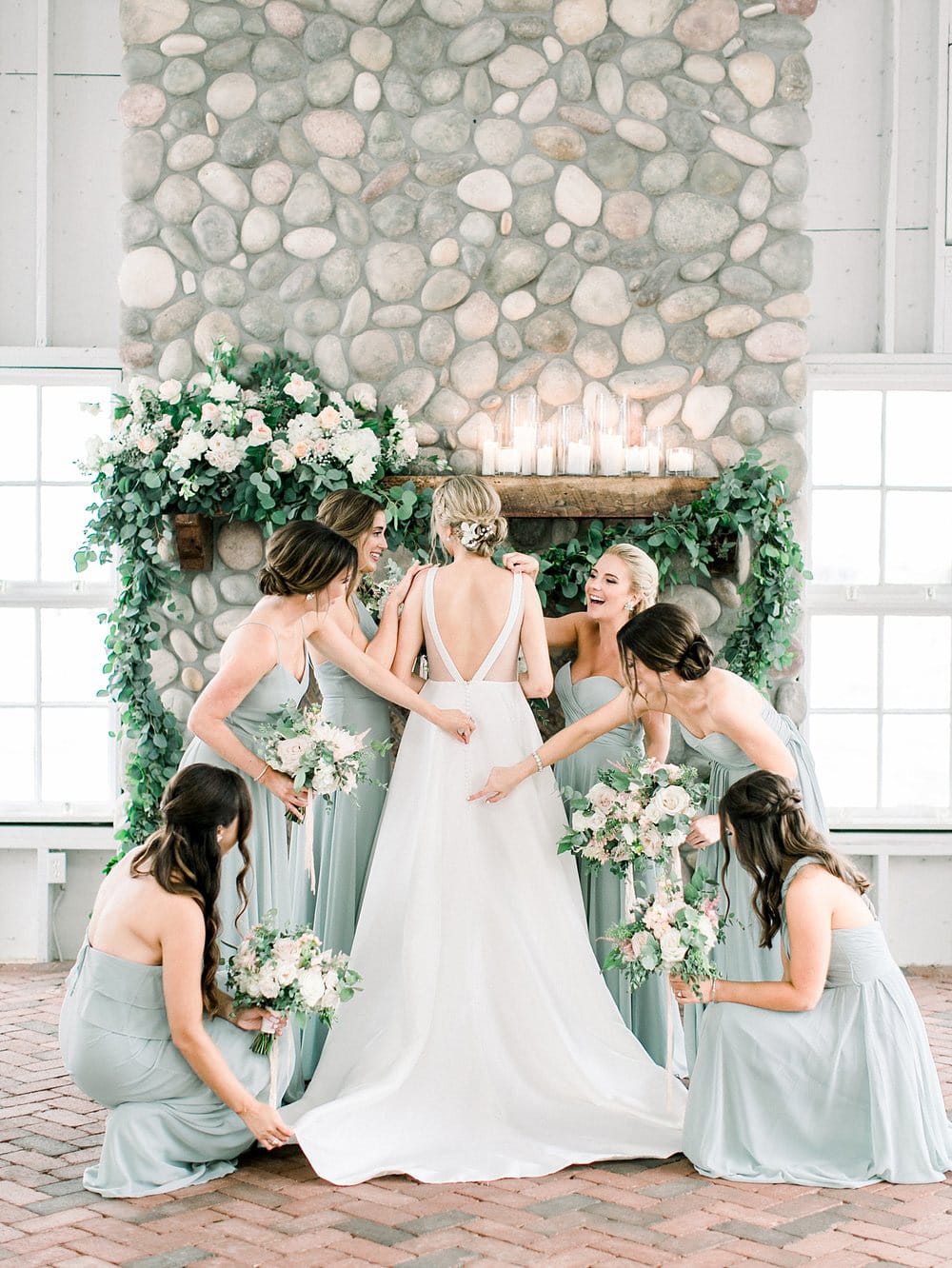 Bride in a white wedding dress and her bridesmaids in a green dresses