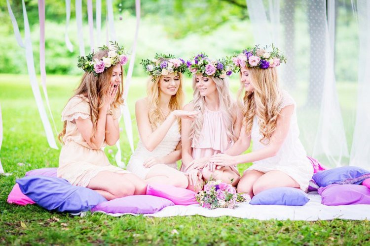 Bride and her bridesmaids are sitting on a grass