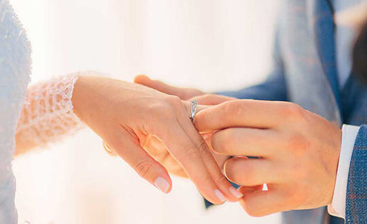 Groom is taking on a ring on a bride hand