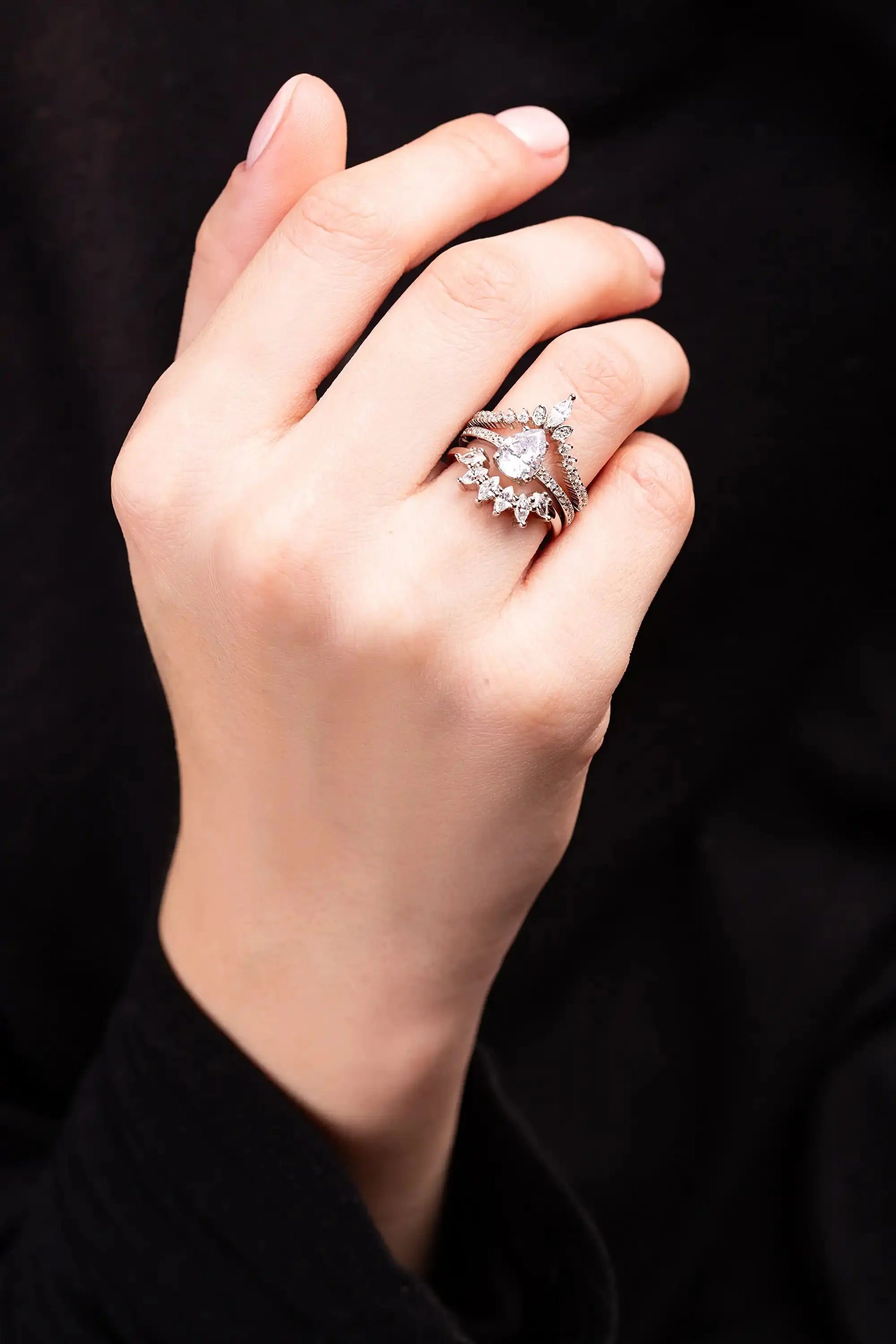 White Gold Ring set for a women with white topaz gemstones. Woman put ring on her finger