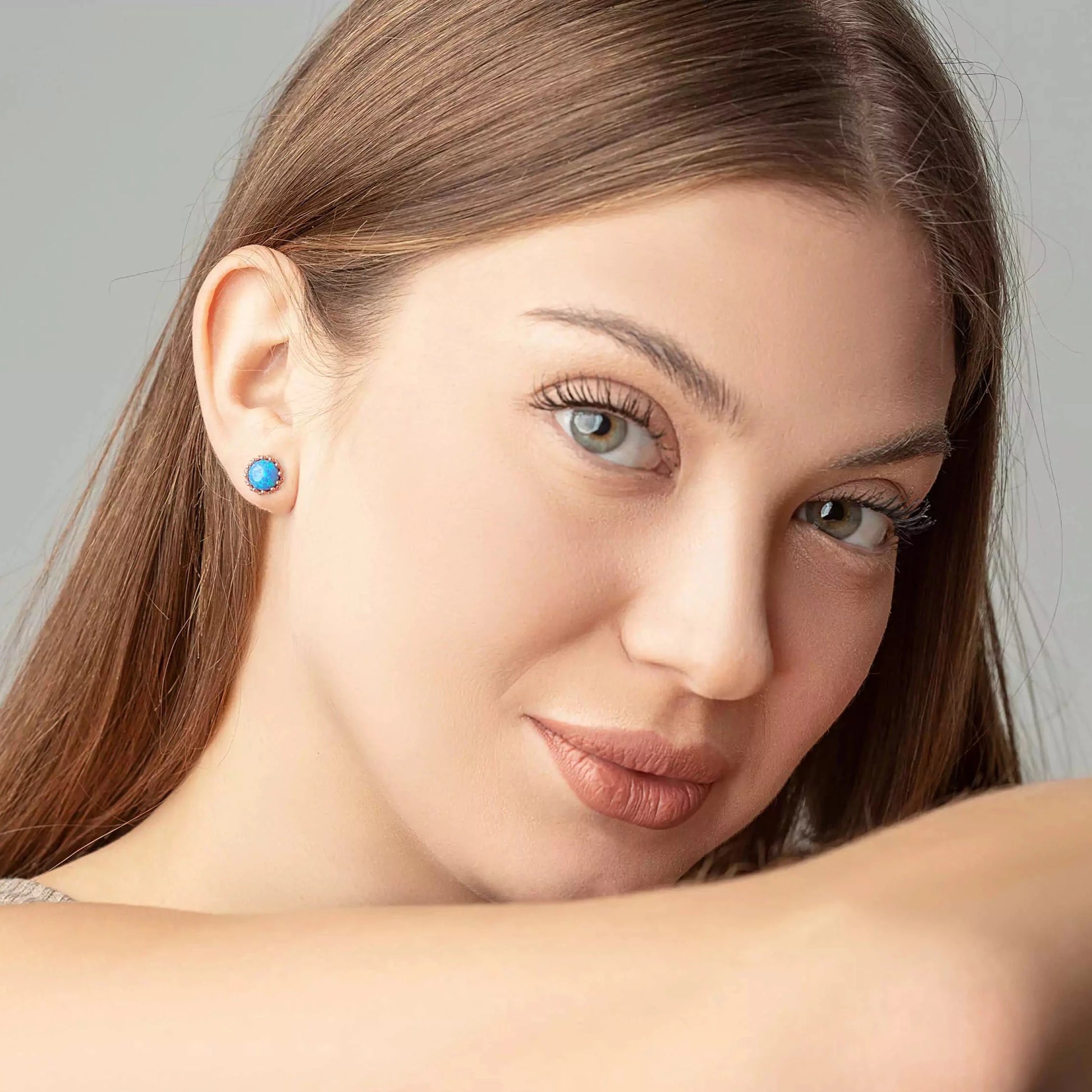 Blue opal crown studs on a woman ears