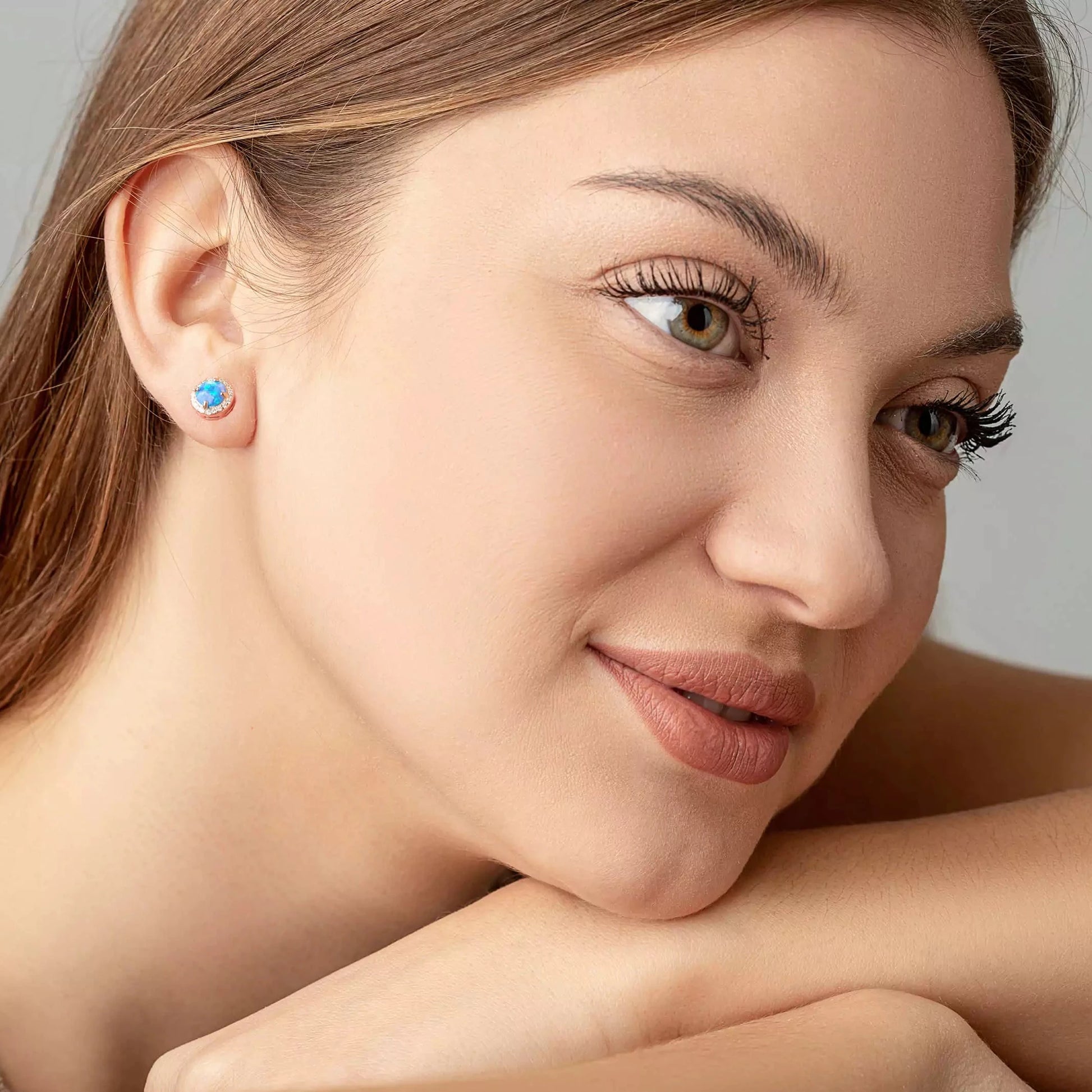 Blue Opal Round studs on a woman ears