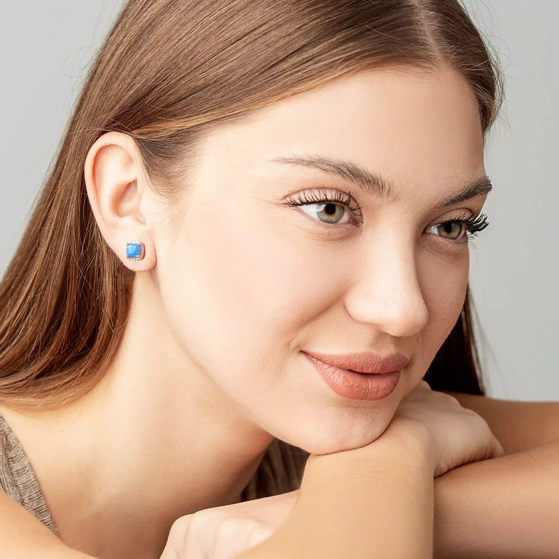 Blue Opal square studs on a woman ears