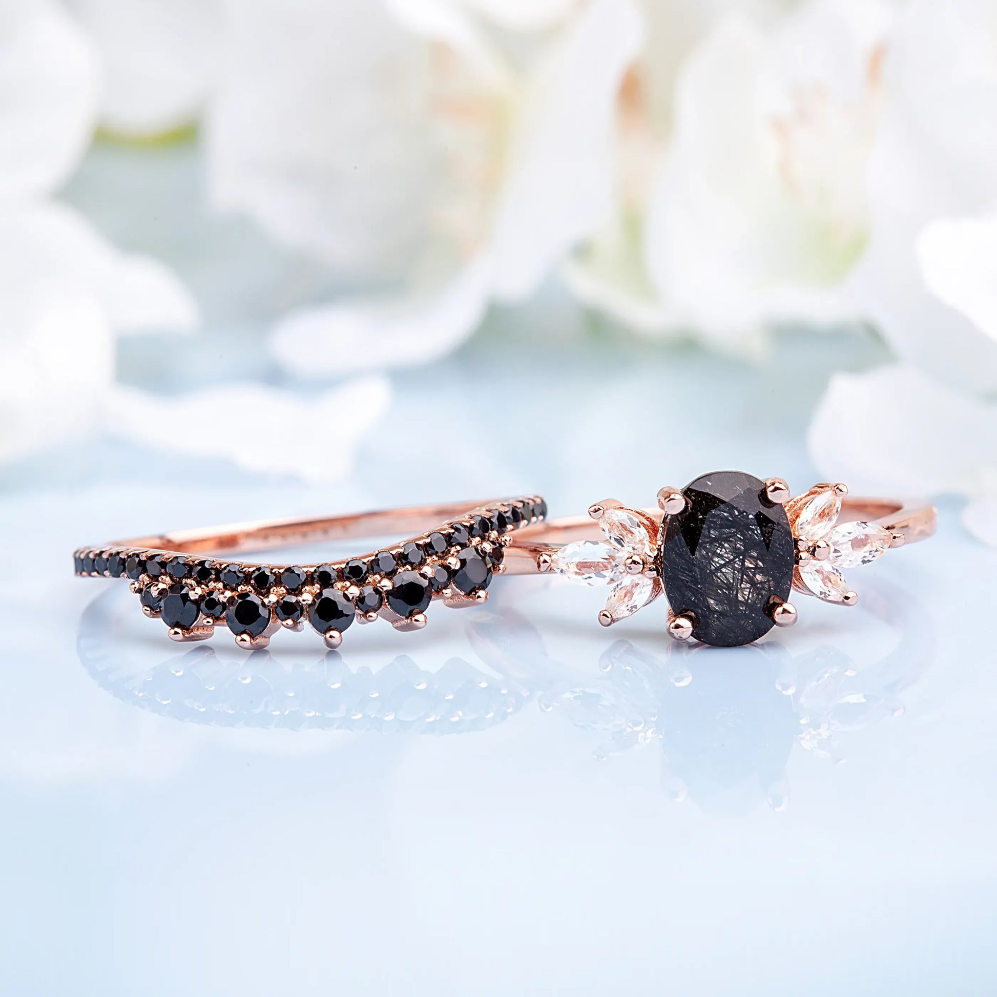 Bridal set with stacking rings, including a black gemstone engagement ring and matching wedding band for a modern look.