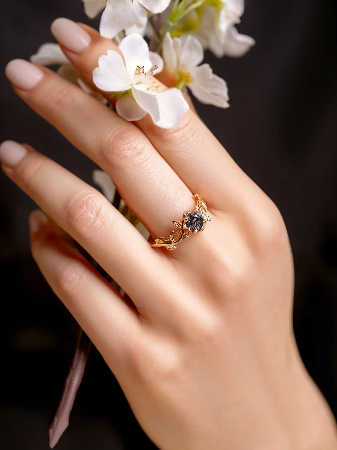 Ring for women with black quartz gemstone in a shape of twig. Ring is placed on a woman's hand