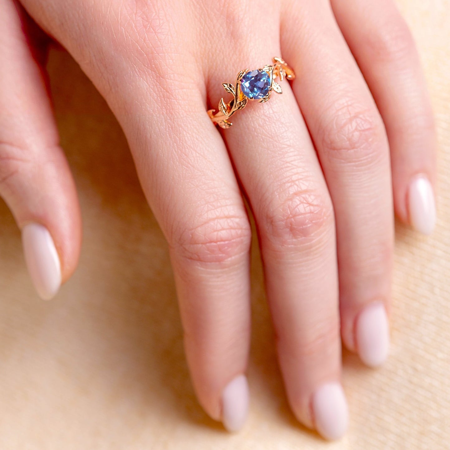 Ring with a blue alexandrite stone on a tender woman hand