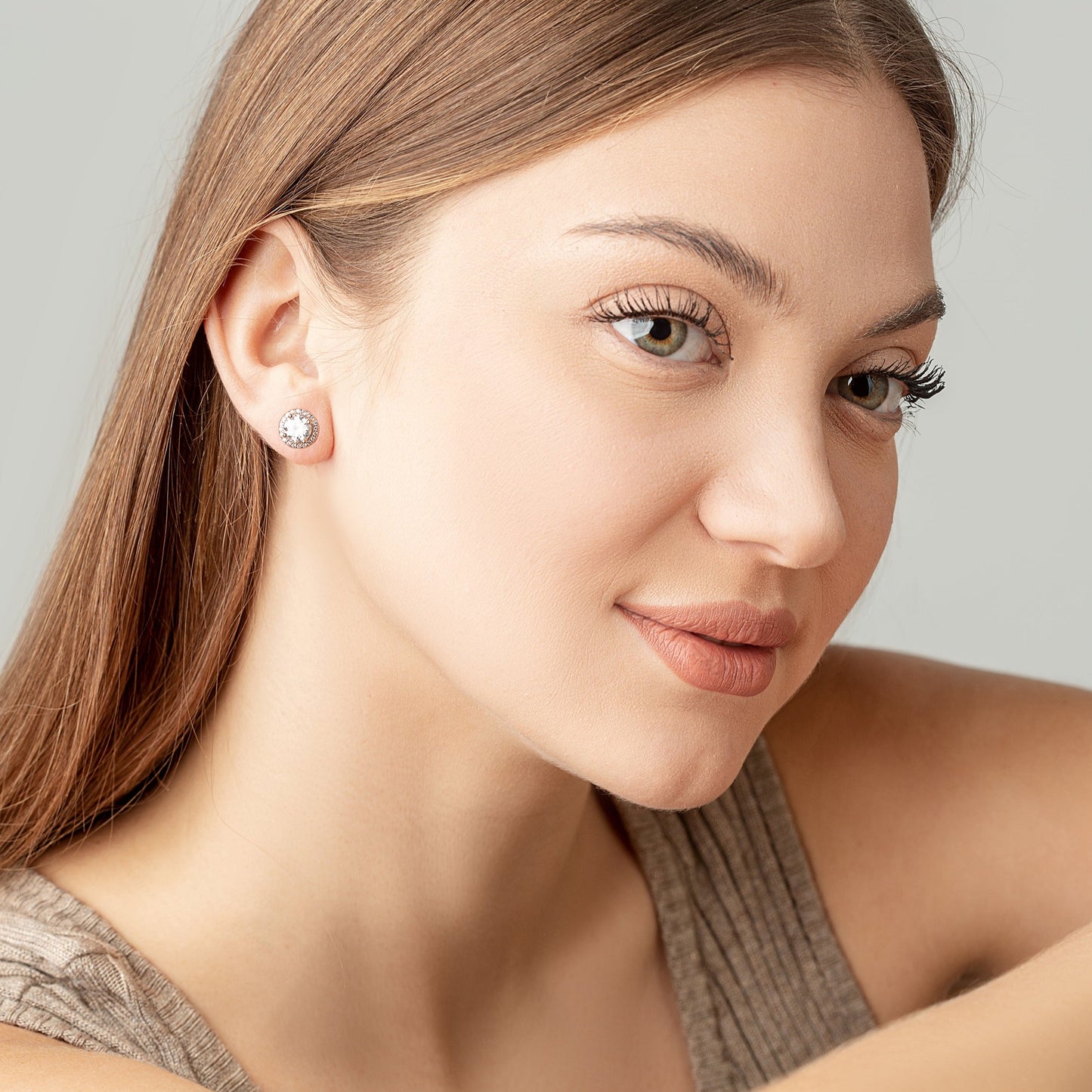 Two Moissanite round studs on a woman ears