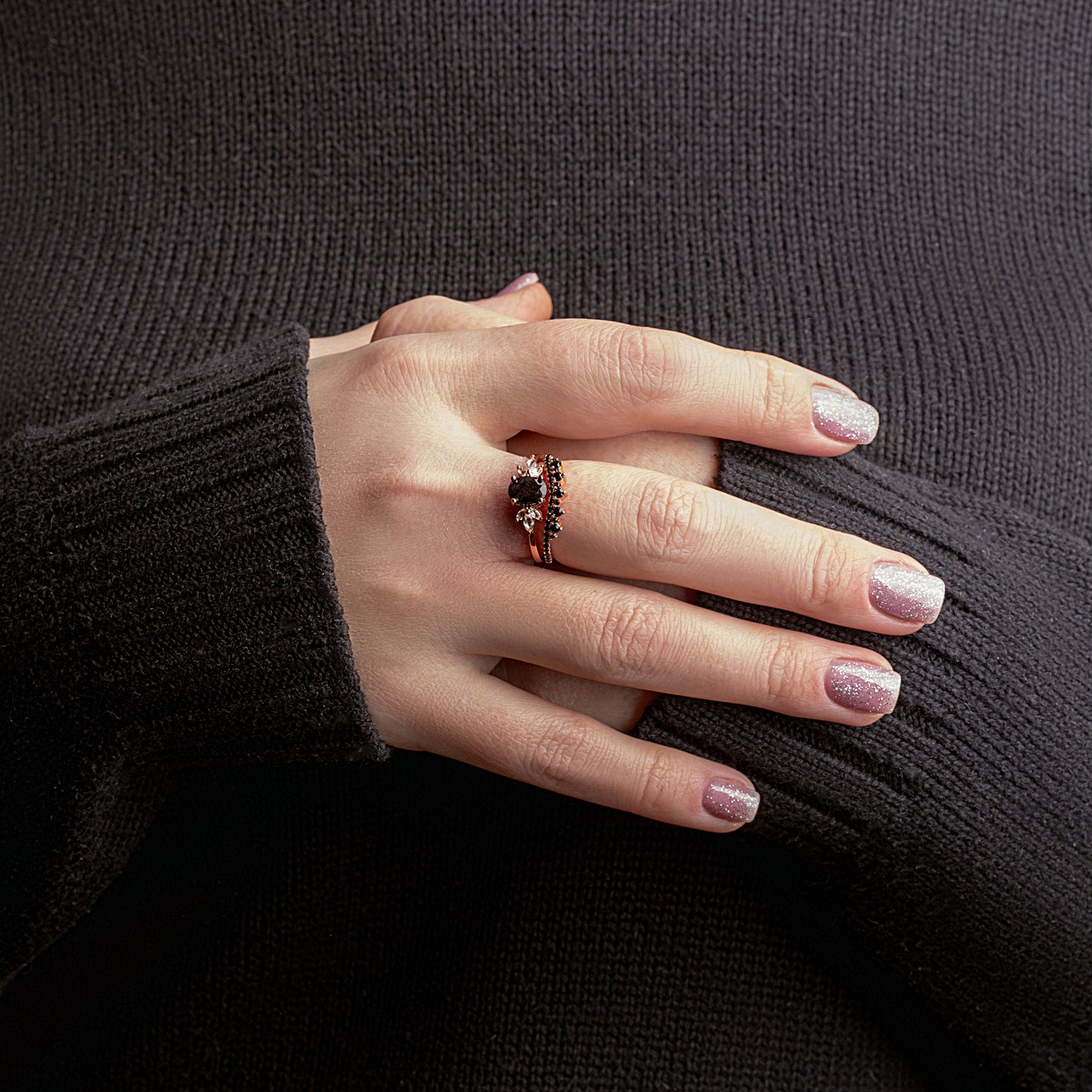 Two rings with a Black Rutilated Quartz as the main stone, White Topaz and Black Spinels on a woman hand