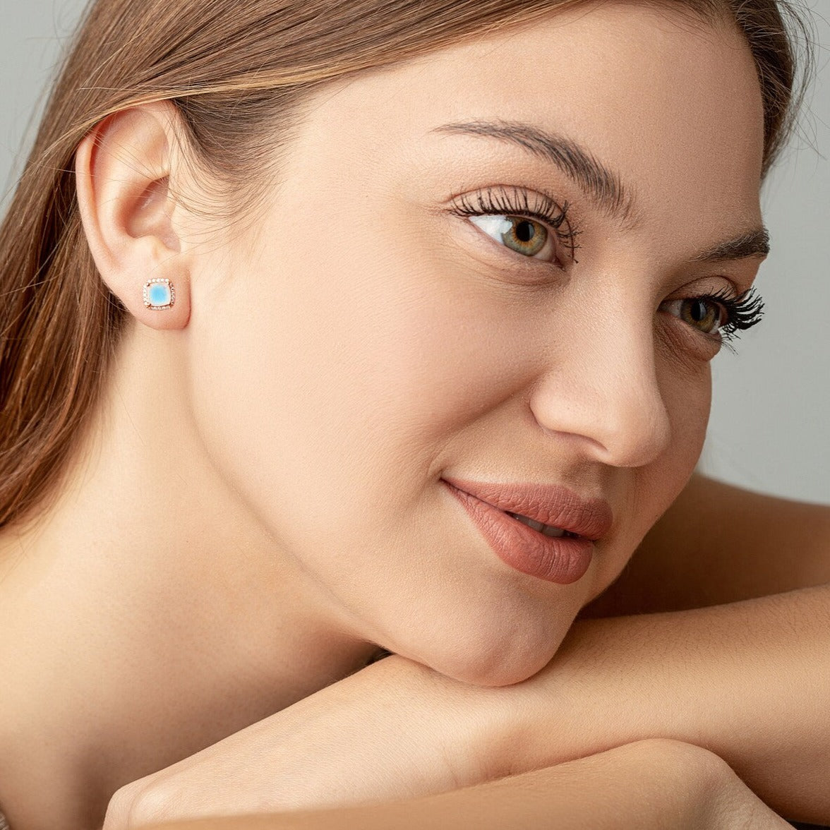 Two Moonstone Square studs on a woman ears