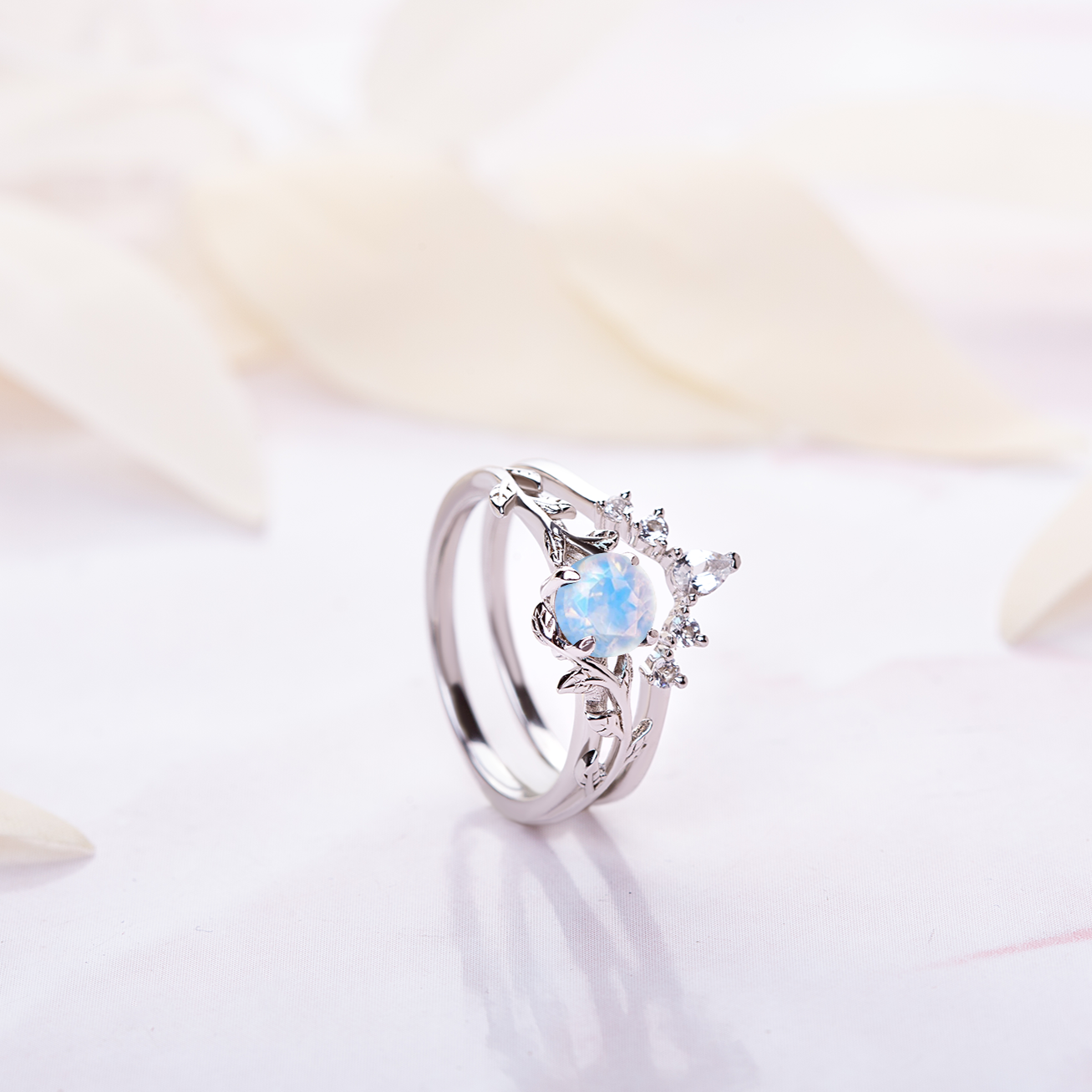 White Gold nature-inspired ring set with moonstone and topaz gemstones, featuring a twigs and leaf design for engagement or wedding rings.